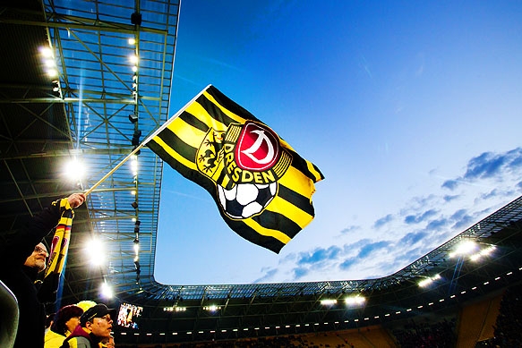 Dynamo Dresden Flagge vor Flutlicht und Abendhimmel